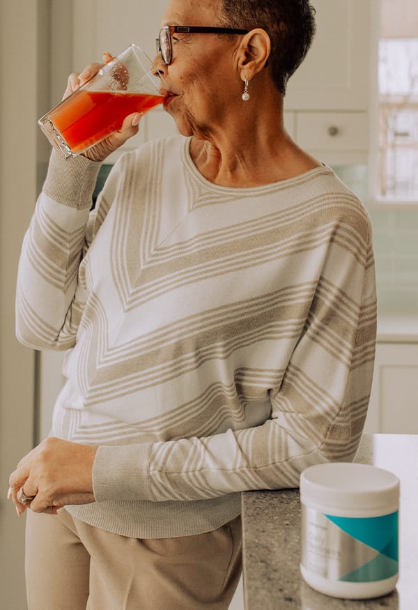 Elderly woman drinking glass of Daily Wellness