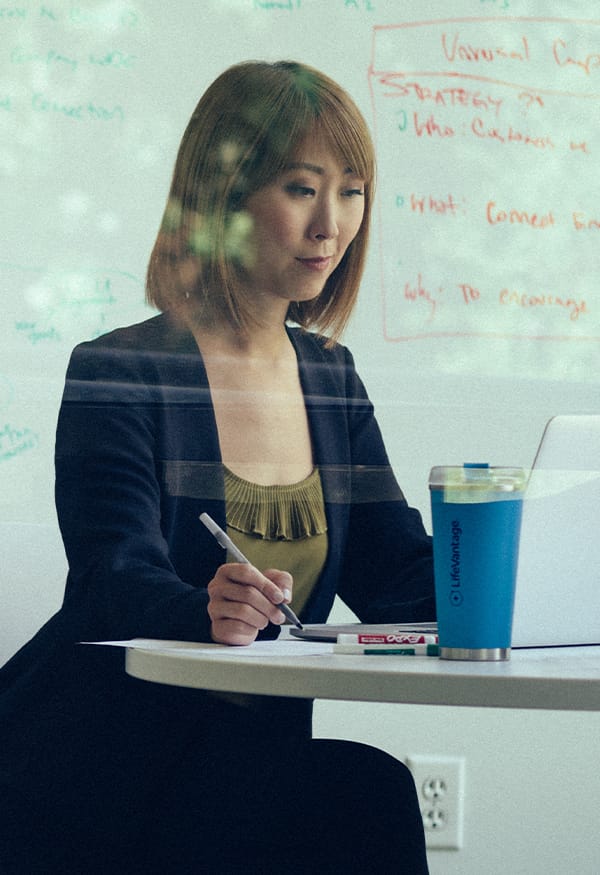 Woman working on her laptop with a LV cup on the desk