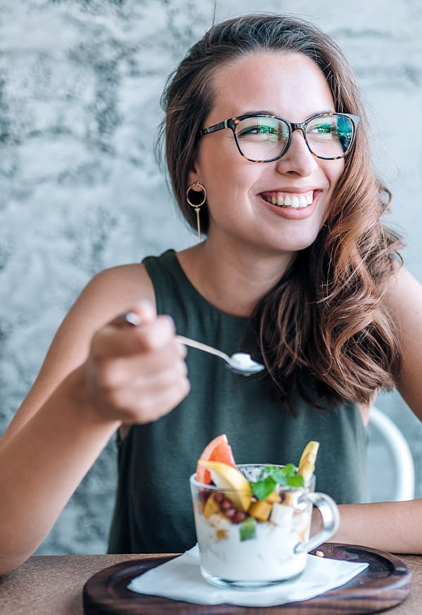 Woman eating fruit and yogurt