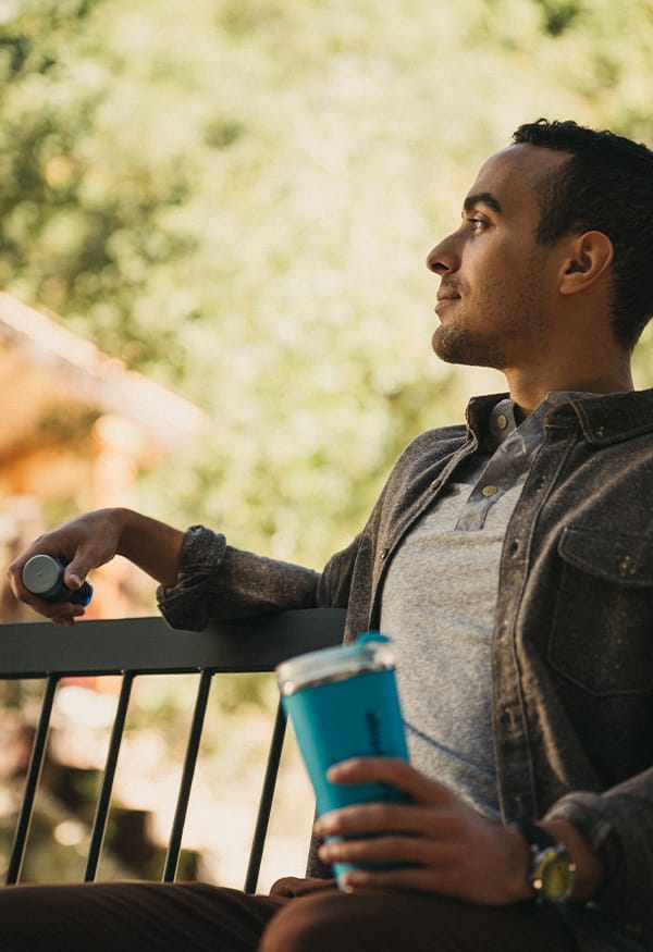 Young man on a bench with a LifeVantage tumbler